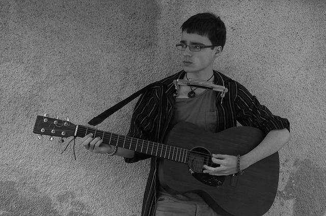 Gitaar spelen in combinatie met het bespelen van de mondharmonica afbeelding